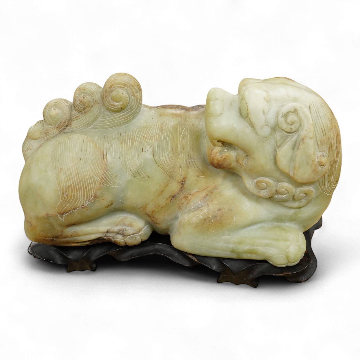 A large Chinese bowenite jade model of a lion dog, wood stand, 44cm